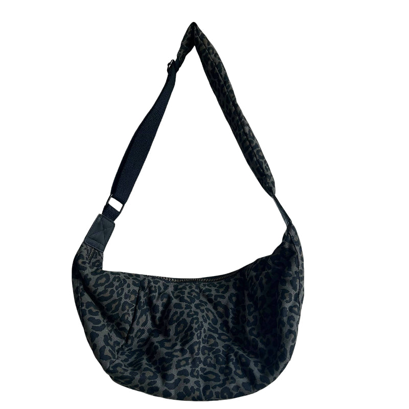 A black and dark gray leopard print crescent shoulder bag with a wide adjustable strap, shown against a plain white background.