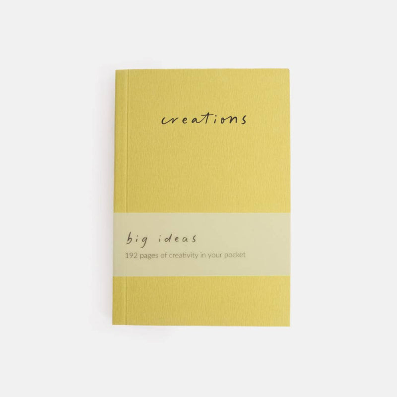 Yellow notebook with 'creations' and 'big ideas' text on a white background