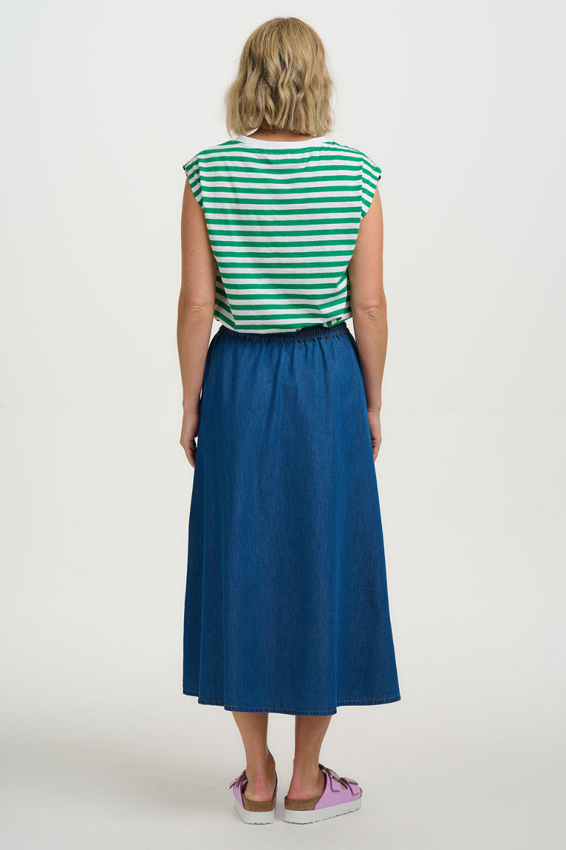 Woman wearing a green and white striped shirt and blue skirt on a white background