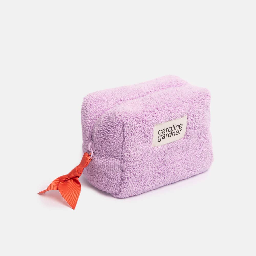 Pink fluffy pouch with a red bow and 'caroline gardner' label on a white background