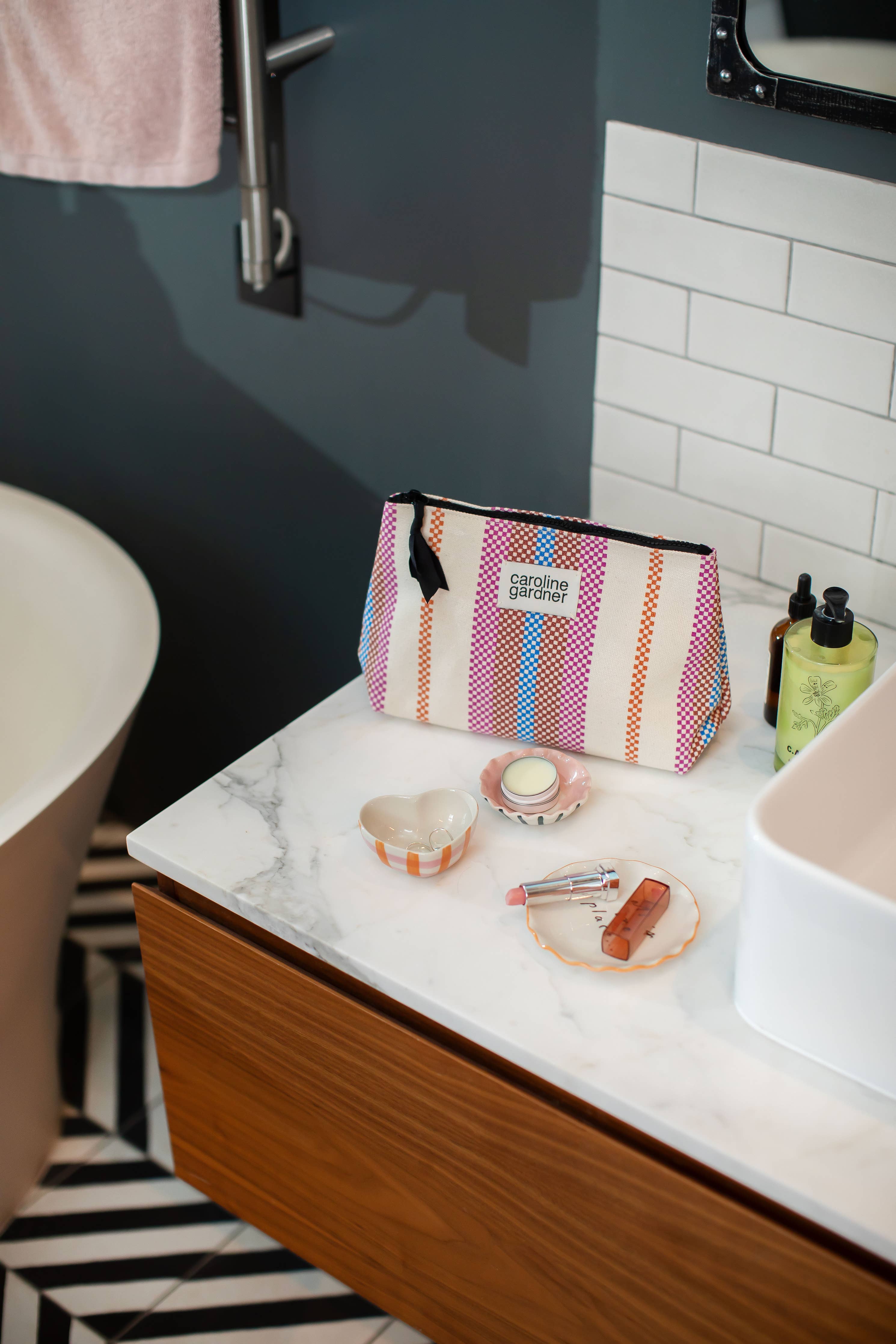 Caroline GArdner striped make up bag on bathroom sink