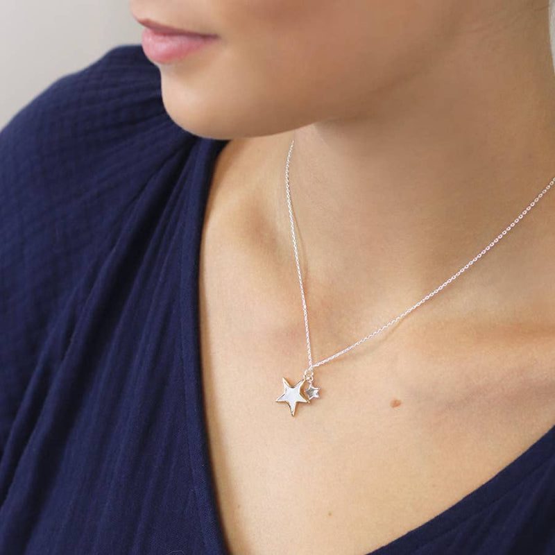 Person wearing a delicate silver necklace with star pendant