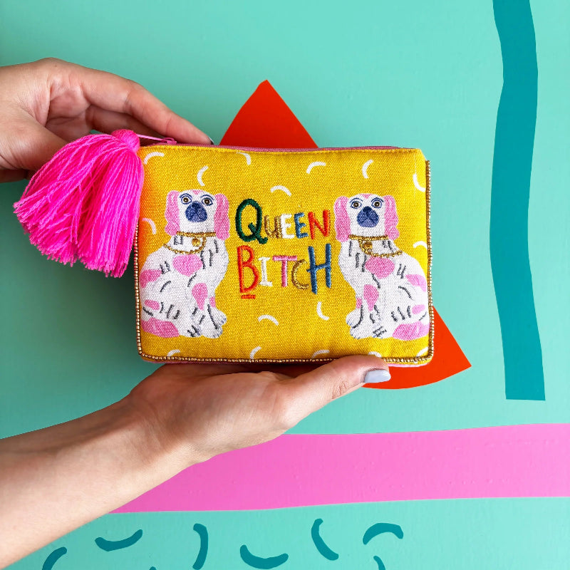 Hand holding a yellow pouch with dog illustrations and colorful text against a bright background