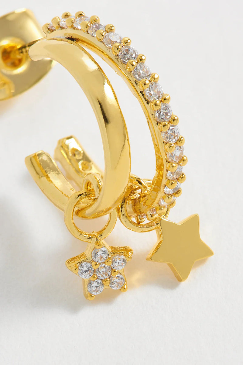 Gold hoop earring with star charms on a light background