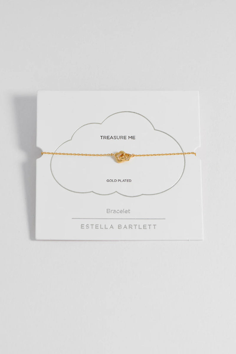 Gold bracelet on a white card with 'Estella Bartlett' branding on a light gray background