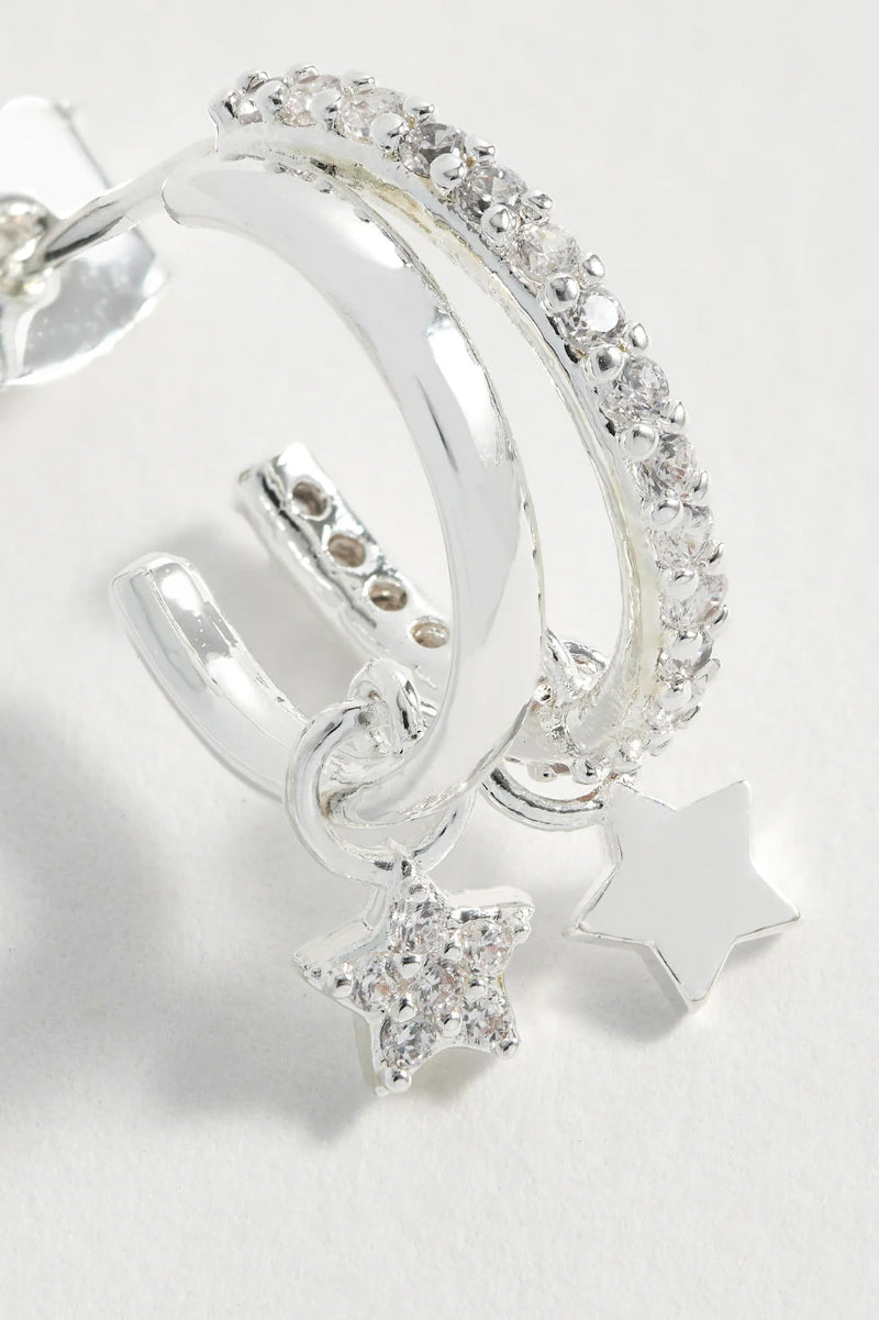 Silver hoop earrings with star charms on a light gray background