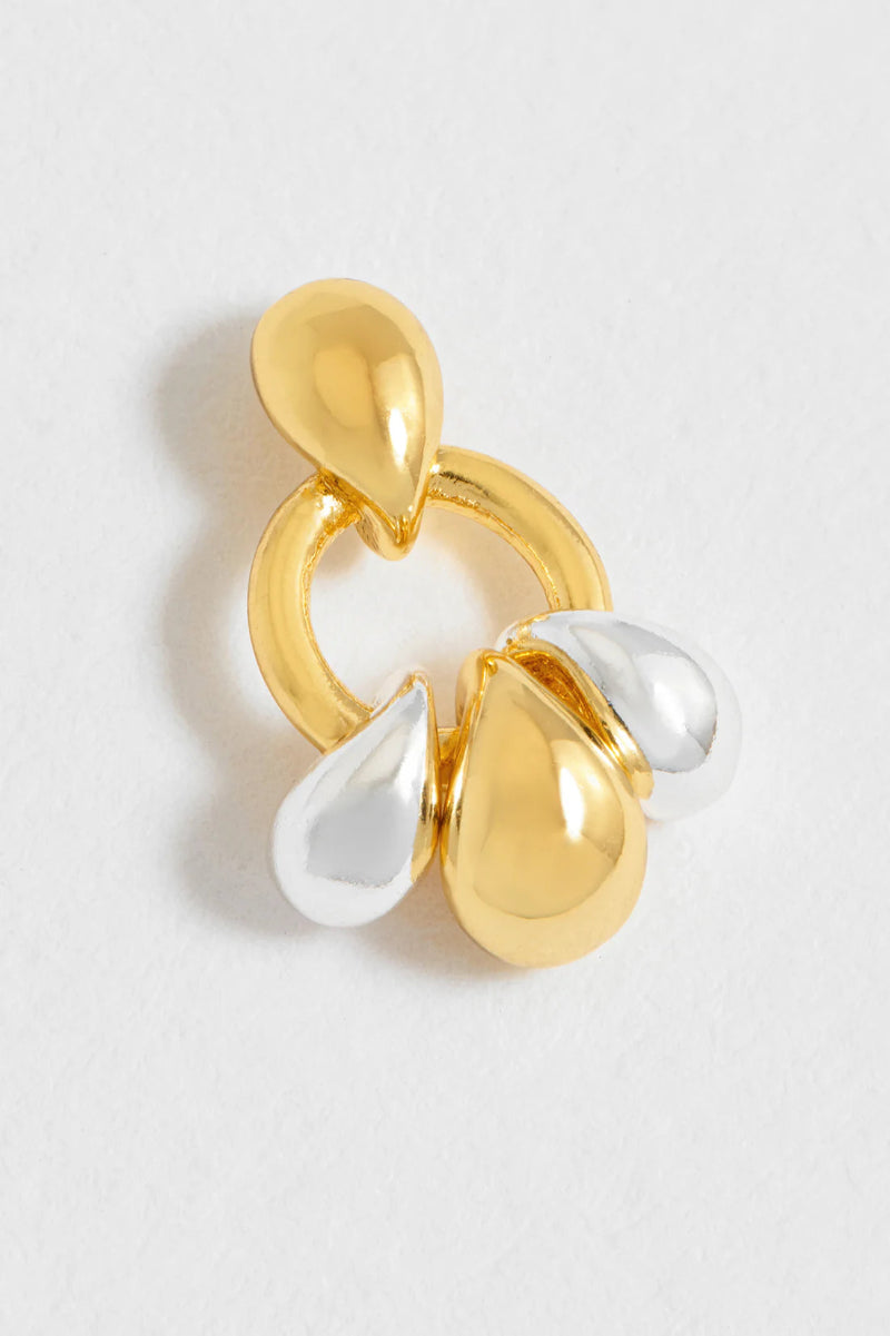 Gold and silver teardrop-shaped earring on a light gray background