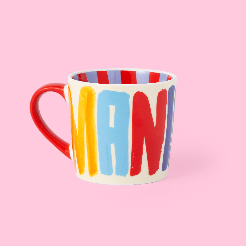 Colorful mug with 'MANIFEST' on a pink background