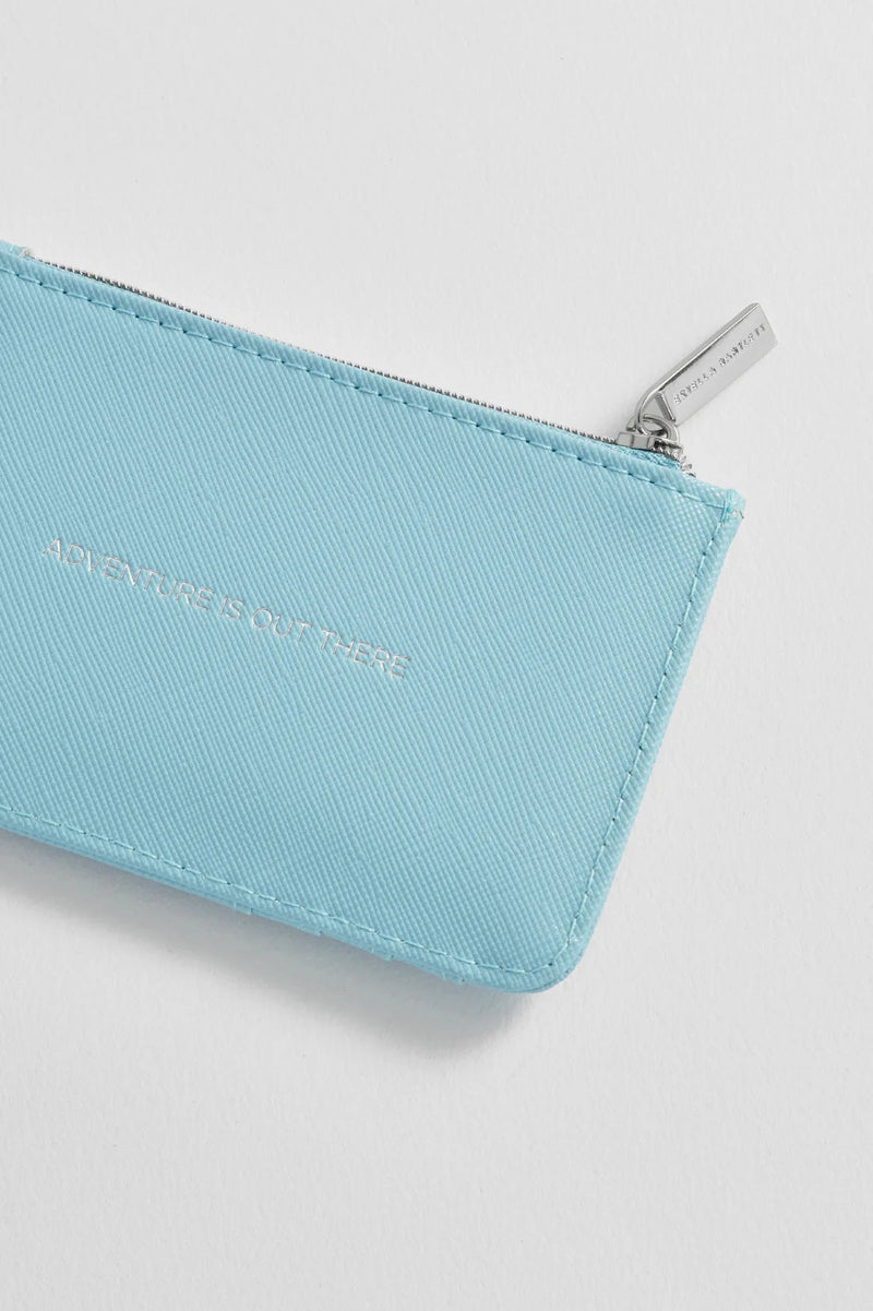 A light blue zippered pouch with silver-tone hardware and embossed text, photographed on a clean white background.