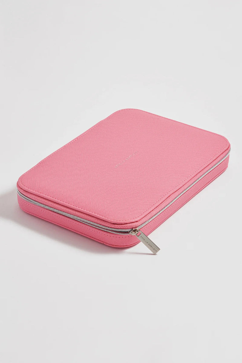 A pink zippered leather jewellery pouch with a silver zipper pull, photographed on a clean white background.