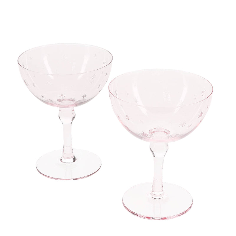 Two clear glass coupe glasses on a white background