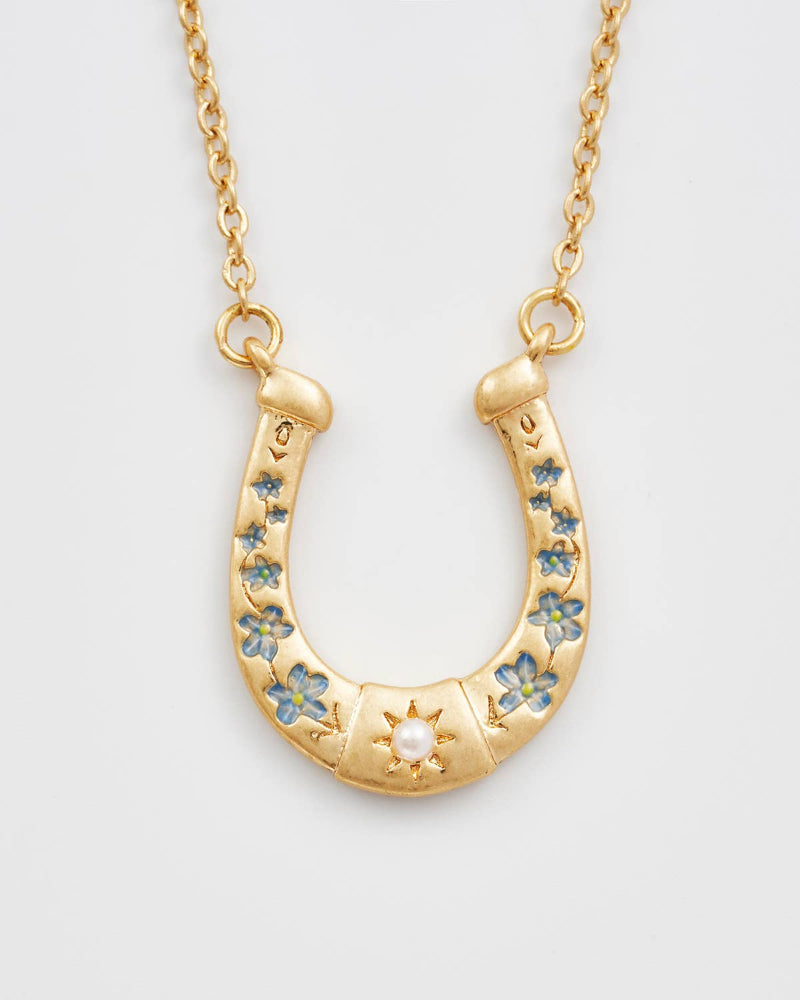 Fable Horseshoe Necklace with floral designs on a light grey background