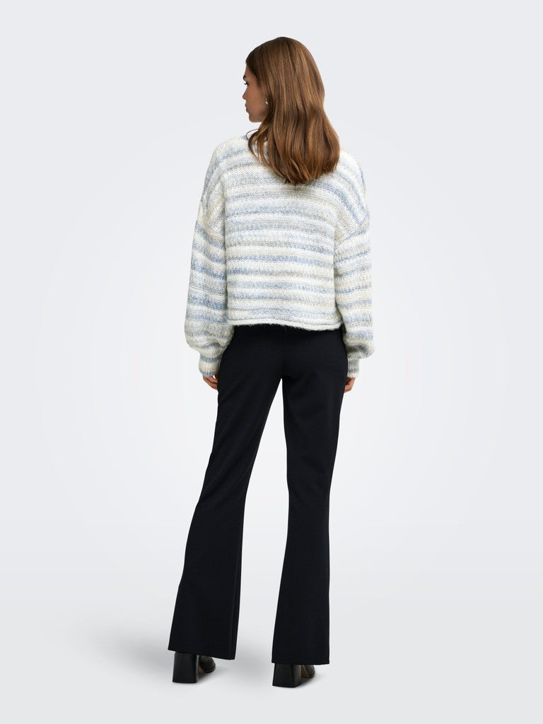 A woman is shown from the back wearing a textured knit sweater with horizontal light blue and white stripes, paired with black flared trousers and black shoes, against a light gray studio background.