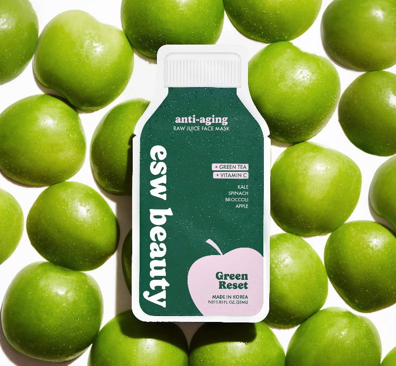 Esw Beauty Green Reset face mask packaging surrounded by green apples on a white background
