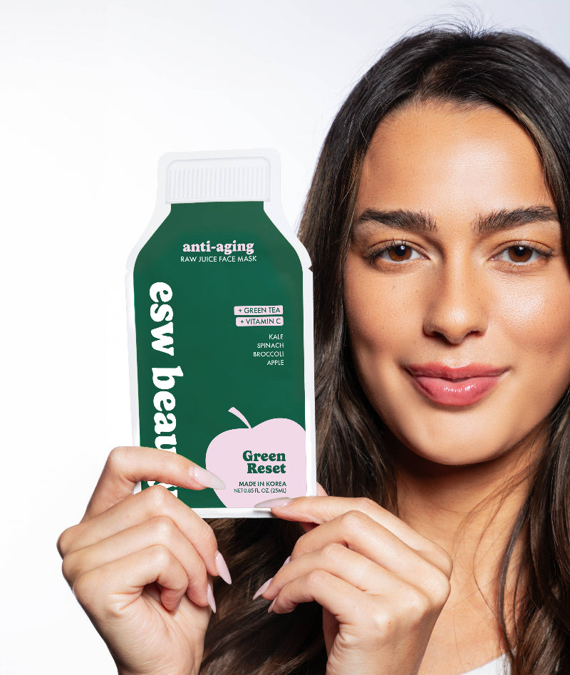 Woman holding an 'esw beauty' green tea mask packaging
