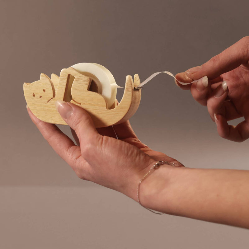 Kitty Sticky Tape Dispenser held by a person's hand against a neutral background