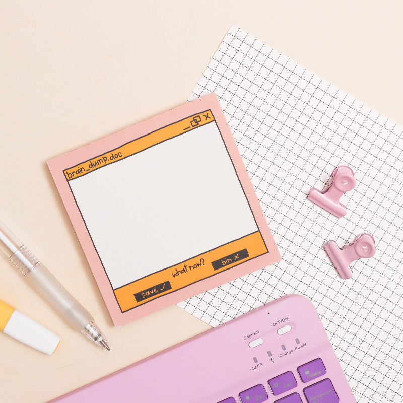 Pink sticky memo pad with digital interface design on a checkered surface with stationery items.
