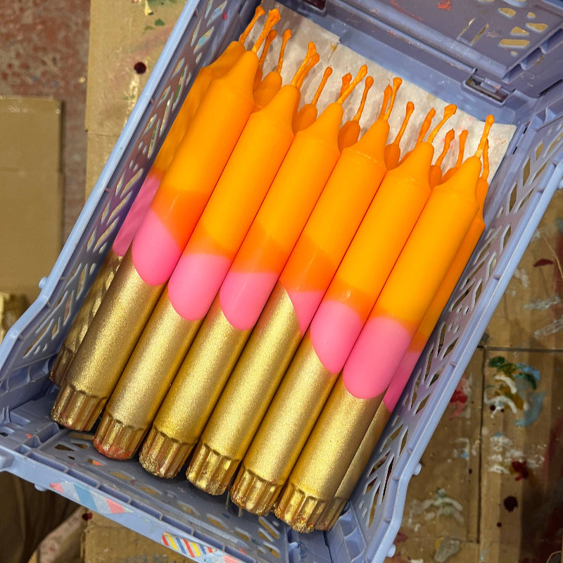 Box containing orange and pink fishing floats with gold bases.