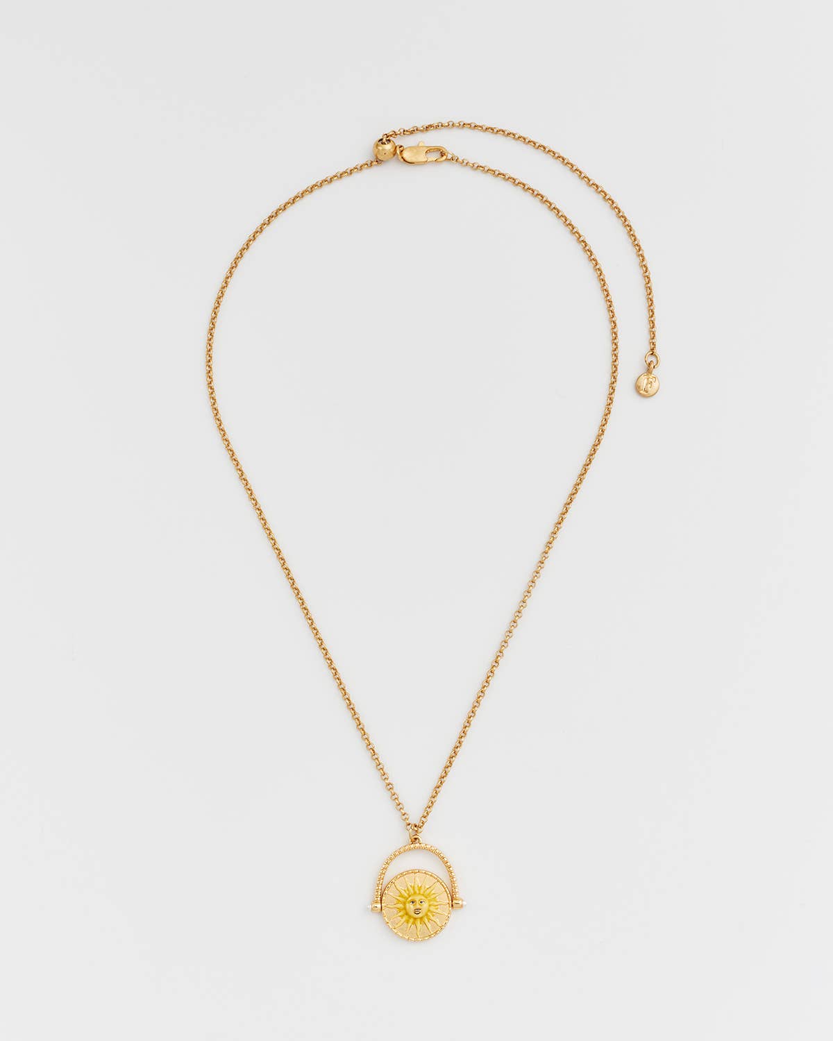 Gold necklace with a pendant on a light gray background