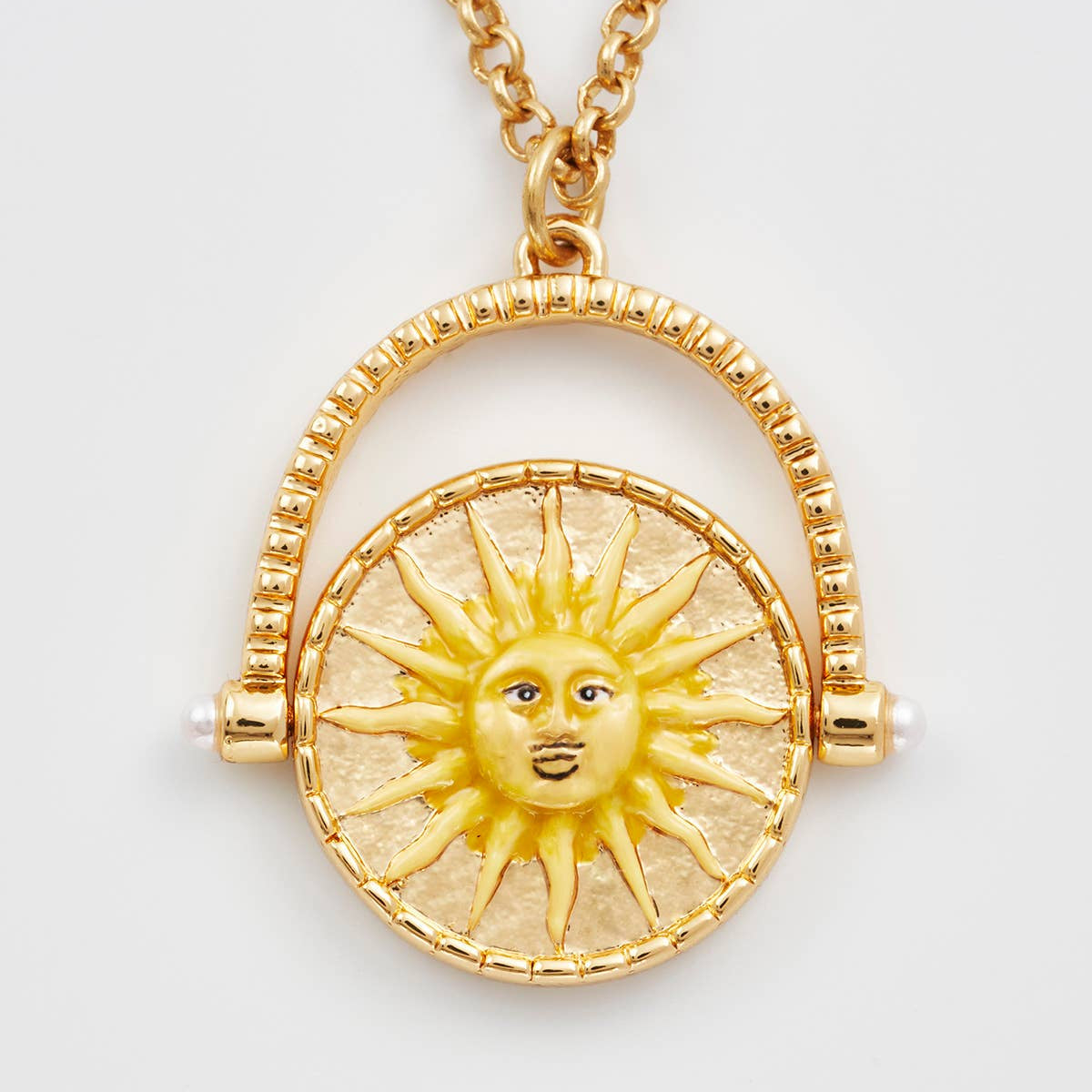 Gold necklace with a sun pendant on a white background