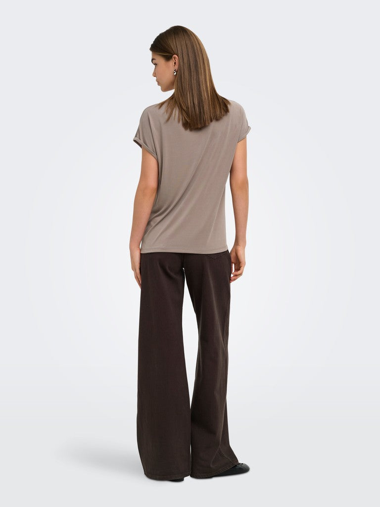 A woman shown from the back wearing a taupe short-sleeve t-shirt and dark brown wide-leg trousers, photographed against a light gray studio background.