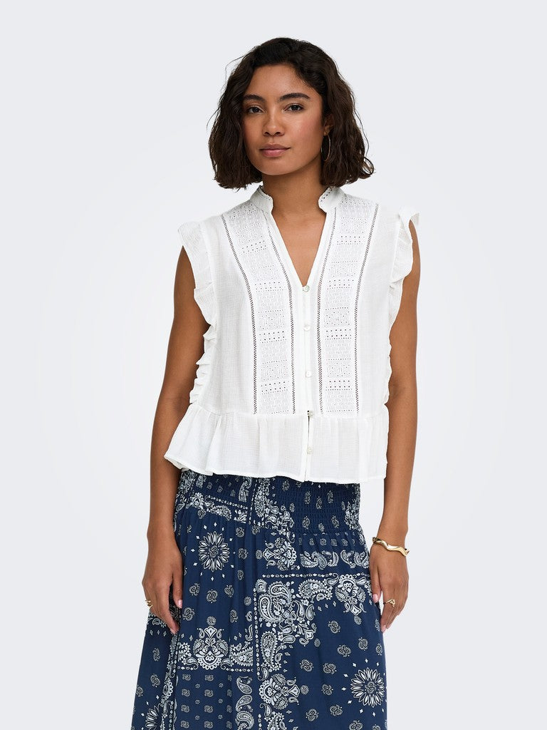 Woman wearing a Only Henny Frill Blouse white sleeveless top with lace details and a blue patterned skirt on a white background