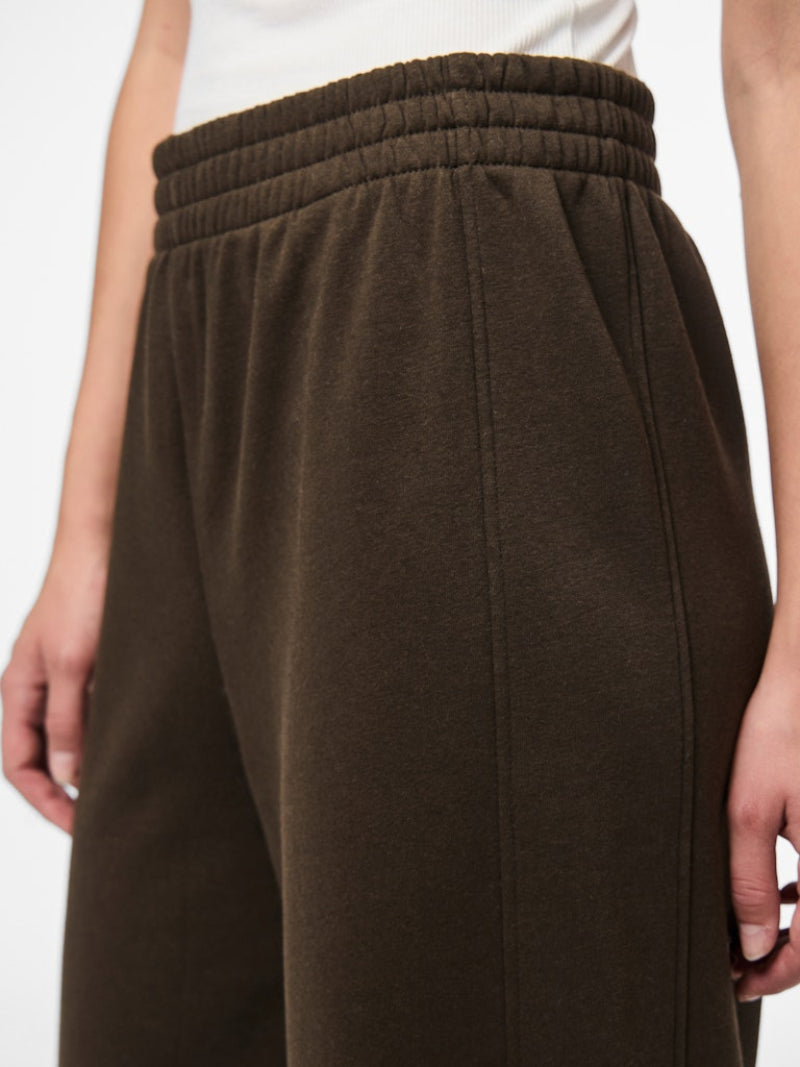 Brown pants worn by a person on a white background