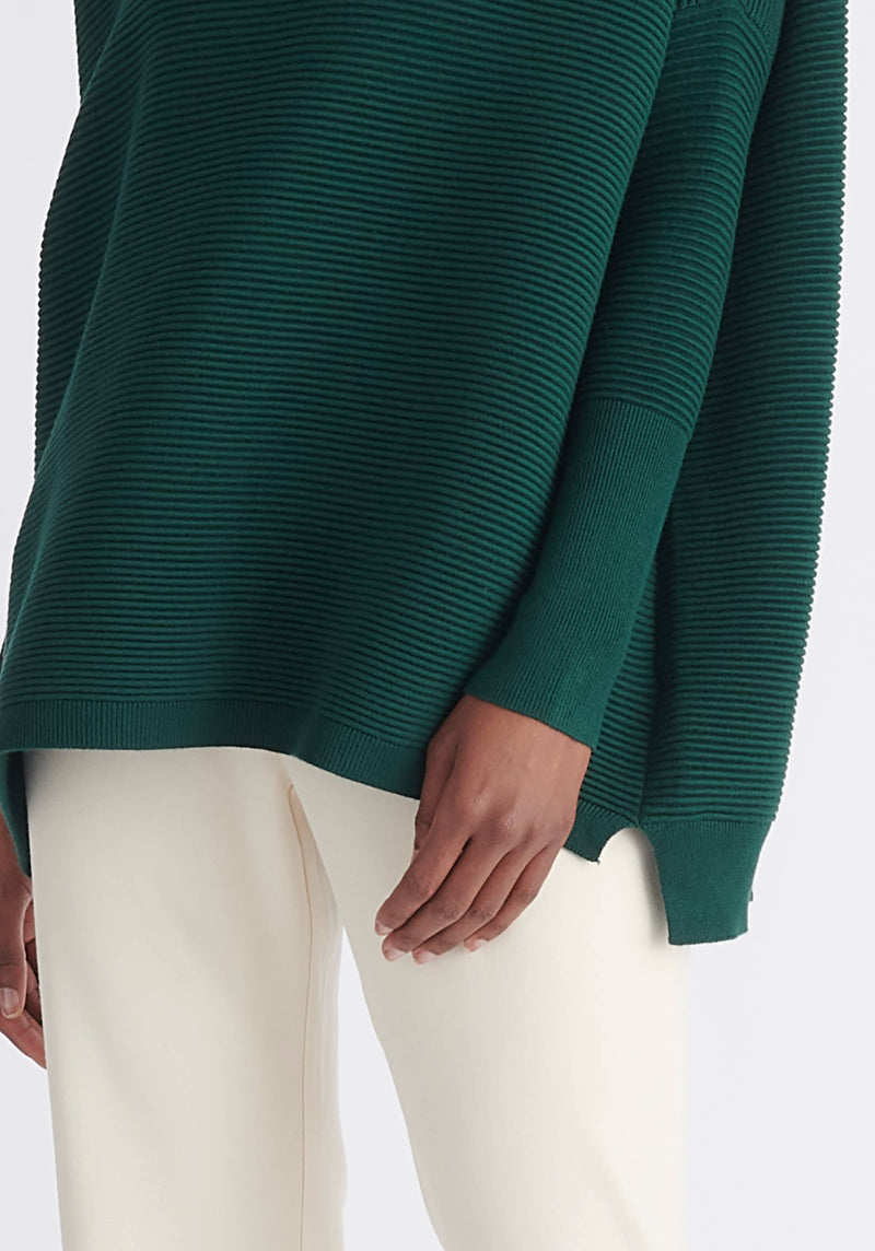 Green sweater worn by a person on a white background