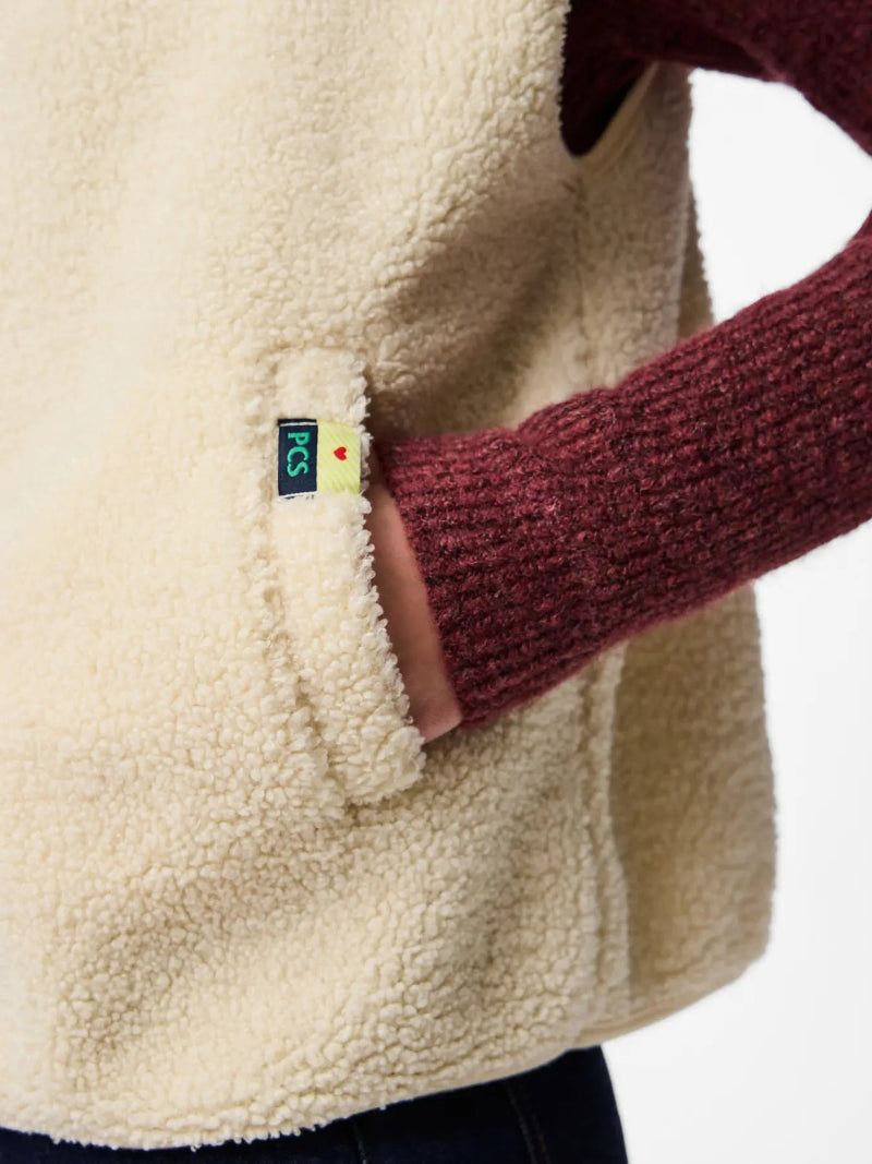 Close-up of a beige fleece jacket with a brand logo on a white background