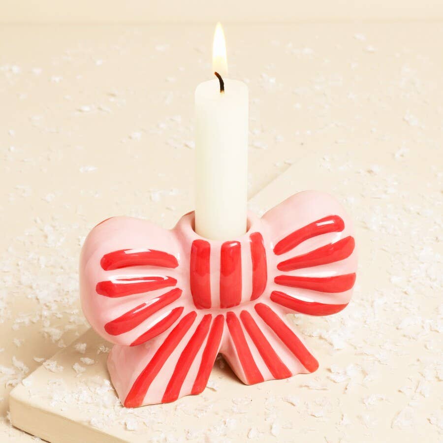 Pink and red bow-shaped candle on a white background