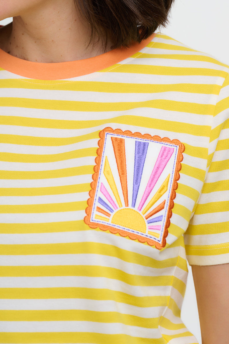 Yellow and white striped shirt with a colorful sun design on a plain background