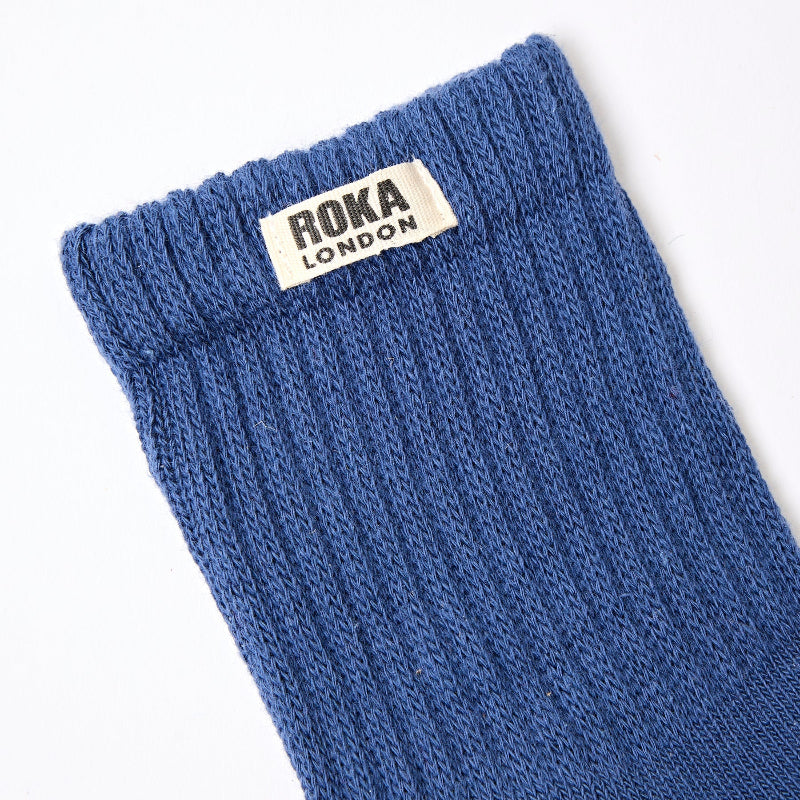 Blue sock with Roka London label on a white background