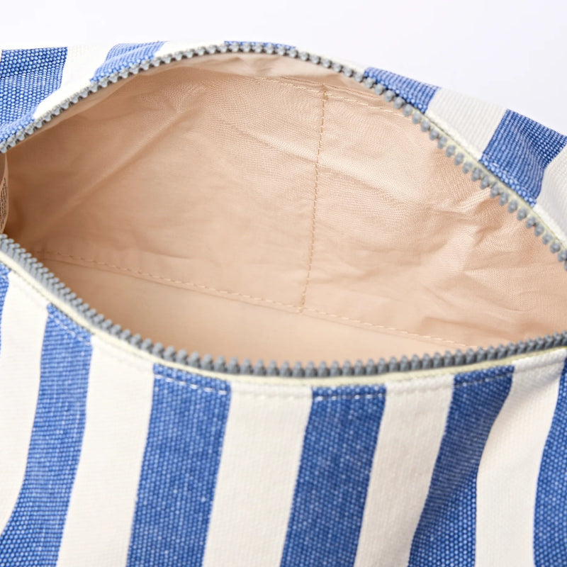 Close-up of a blue and white striped bag with a beige interior.