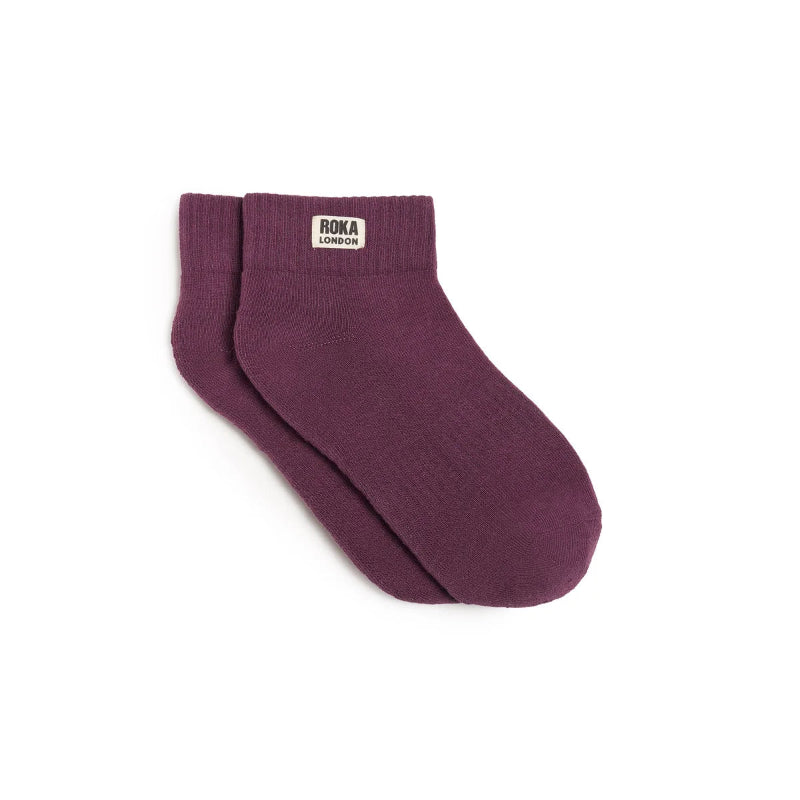 Purple sock with Roka label on a white background