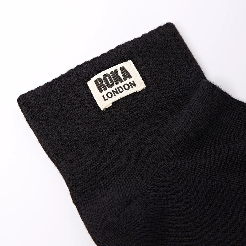 Black sock with Roka London label on a white background