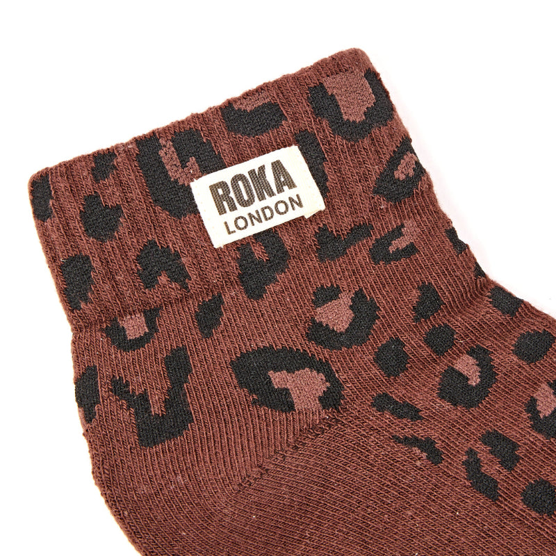 Brown sock with black cheetah pattern and Roka London label on a white background