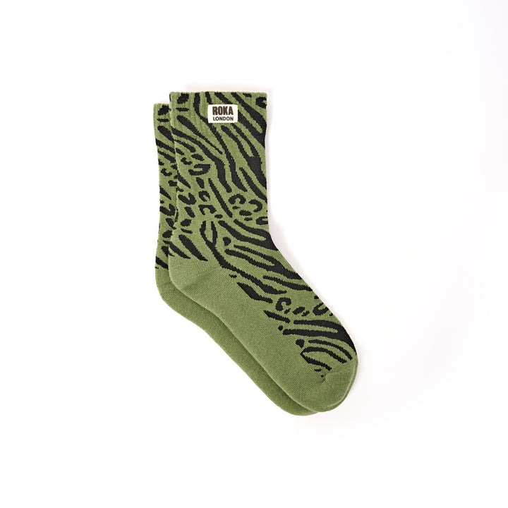 Green sock with black animal pattern on a white background