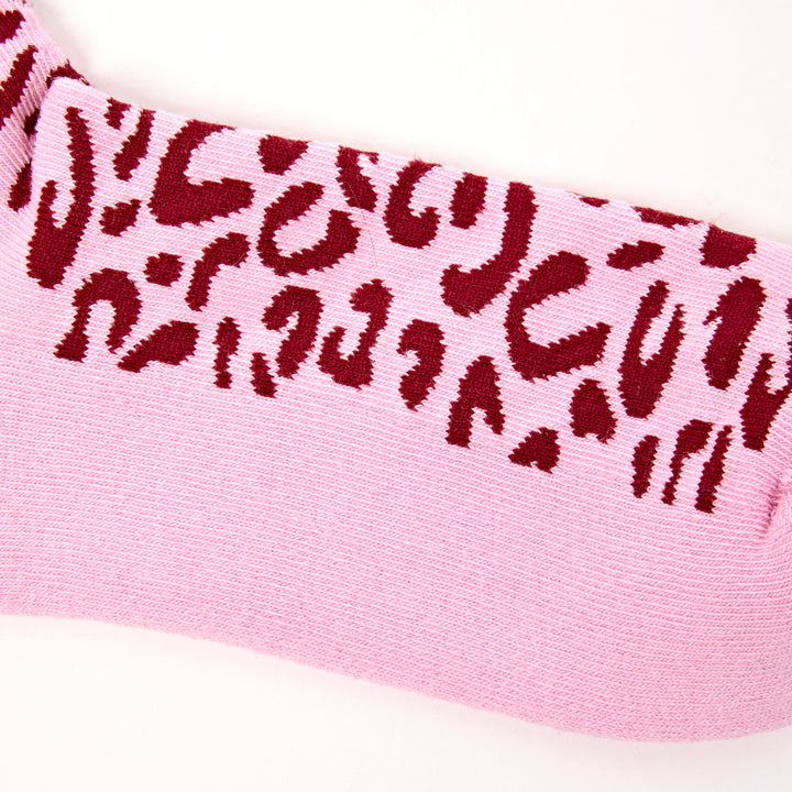 Pink sock with red leopard print pattern on a white background