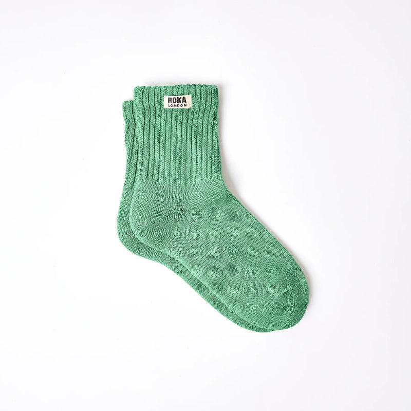 Green sock with brand label on a white background