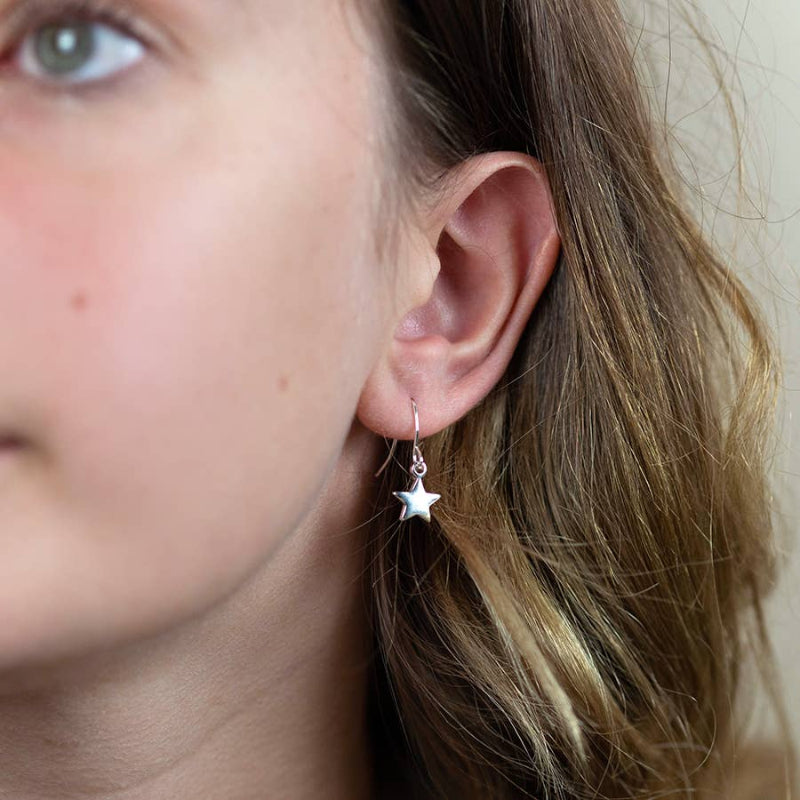 Close-up of a person wearing a star-shaped earring.