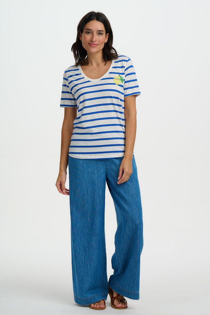 Woman wearing a striped shirt and blue pants on a white background