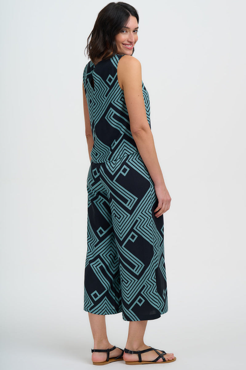 Woman wearing a sleeveless top and trousers with a geometric pattern on a white background