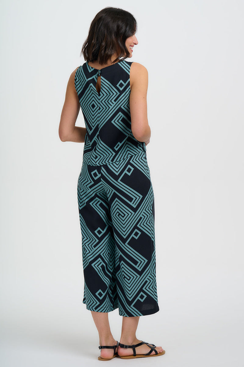 Woman wearing a black and green patterned jumpsuit on a white background