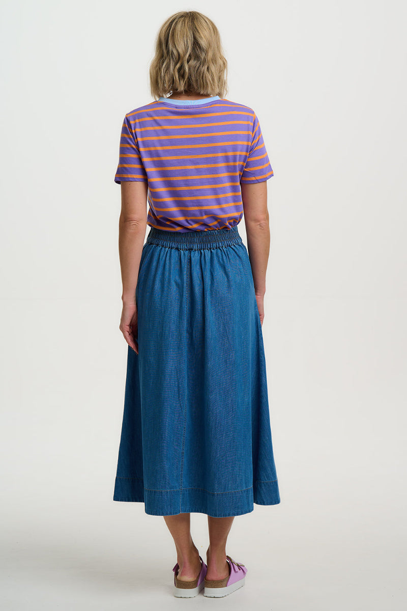 Person wearing a striped shirt and blue skirt on a white background