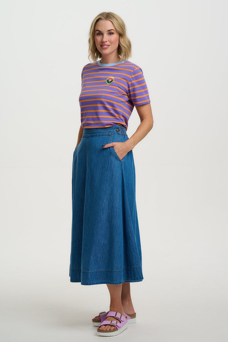 Woman wearing a striped shirt and denim skirt on a white background