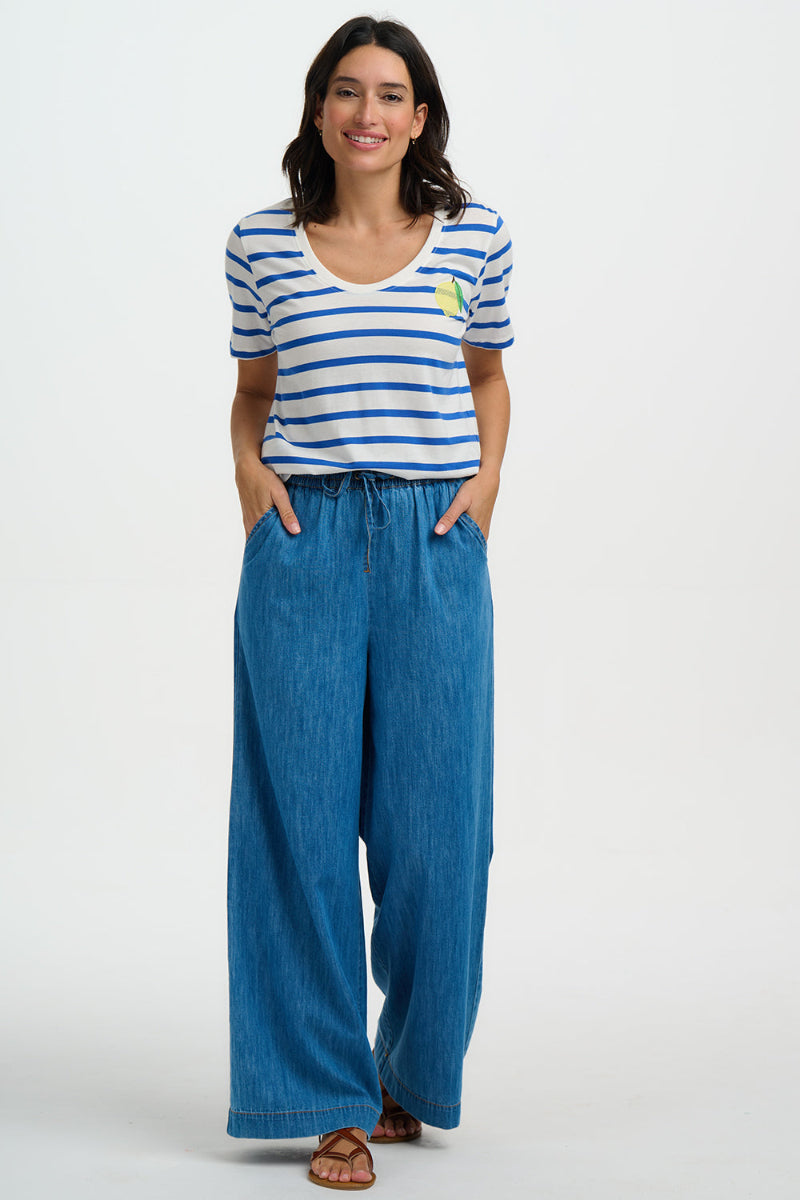 Woman wearing a striped shirt and blue jeans on a white background