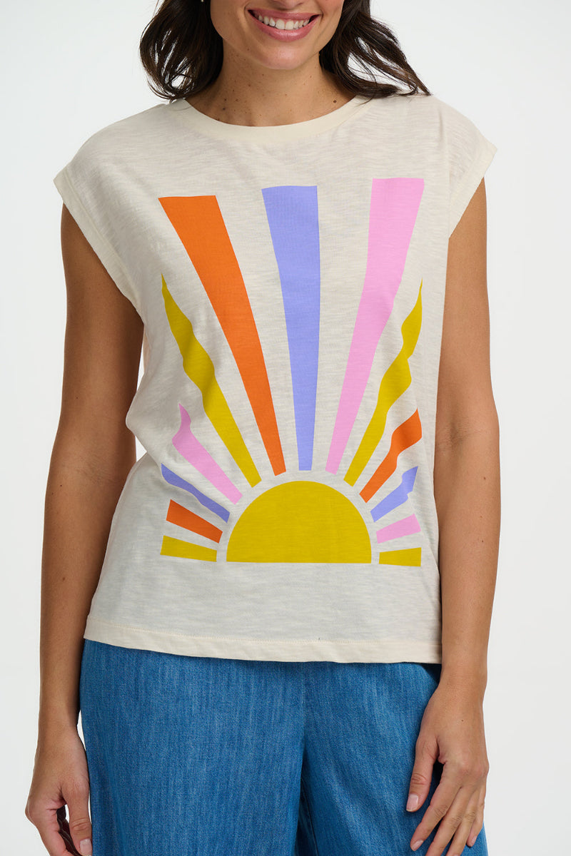 Woman wearing a sleeveless top with a colorful sun design on a white background