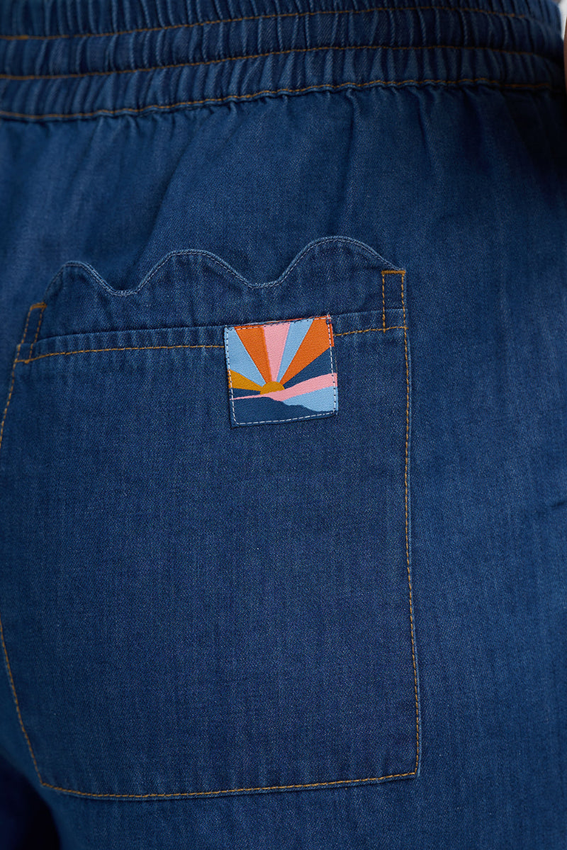 Blue denim pocket with a colorful patch on a blue denim background