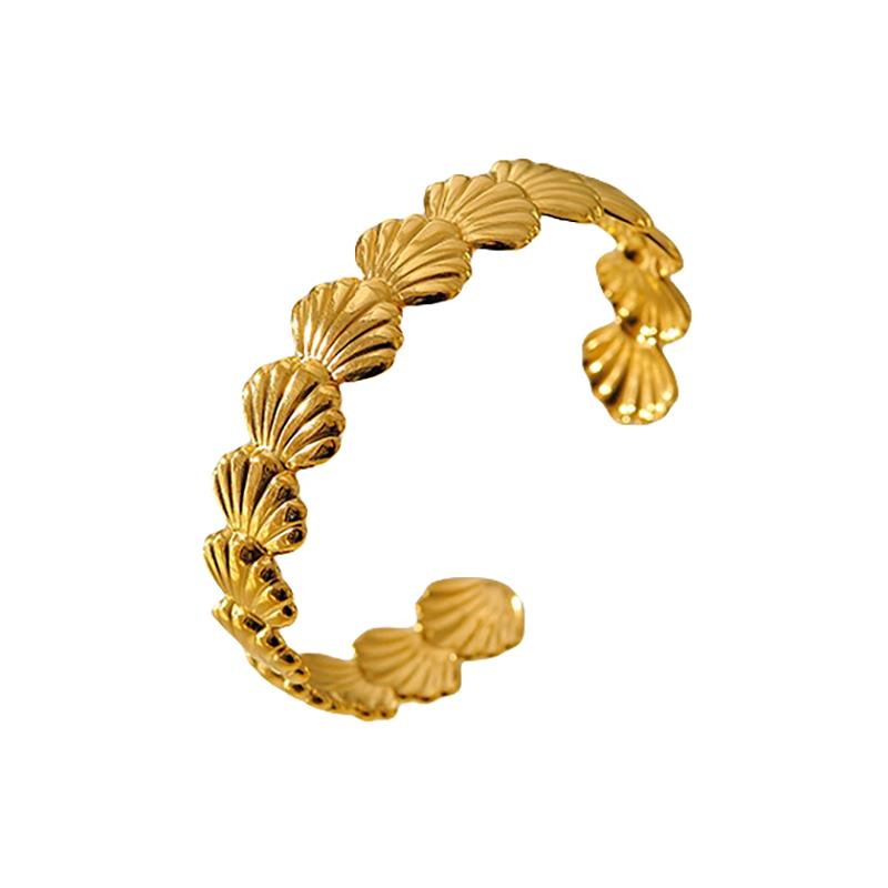 Gold ring with shell design on a white background