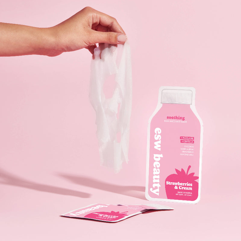 Hand holding a pink package with 'esw beauty' branding on a pink background